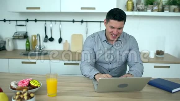 英俊的男人在家里用笔记本电脑慢动作年轻的商人在家用笔记本电脑工作视频的预览图