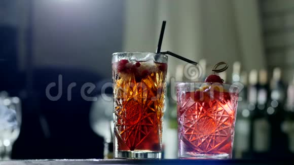 酒精饮料在玻璃与塑料吸管和浆果在烟雾特写视频的预览图