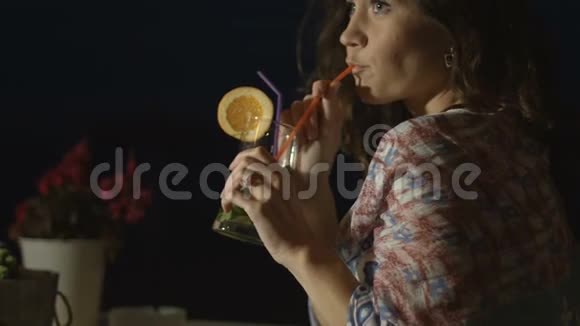 迷人的年轻女子喝着鸡尾酒脸上带着微笑等待约会视频的预览图