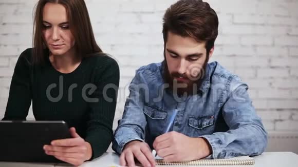 年轻学生正在学习而其中一个正坐在桌子旁睡觉视频的预览图