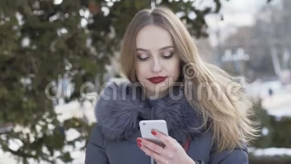 快乐女孩在电话里说着笑在冬天的街道上视频的预览图