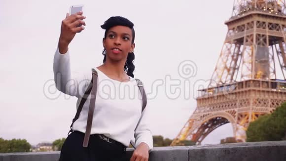 站在离埃菲尔铁塔不远的街道上拍照的美女视频的预览图