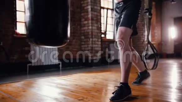 一名拳击运动员在体育馆里用拳击袋进行拳击训练视频的预览图