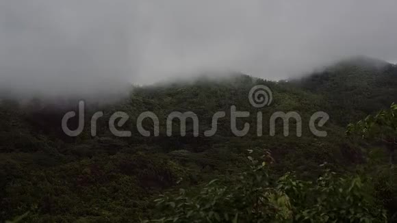 岛上青山在多云多雨的天气下山顶隐藏在白云下视频的预览图