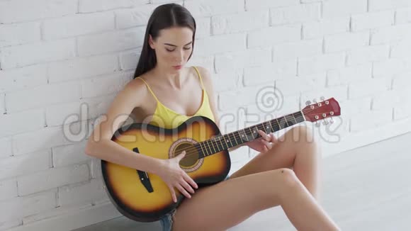可爱的女人在地板上弹吉他视频的预览图
