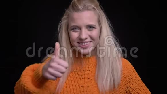 年轻漂亮的白人女性在看镜头时竖起大拇指并带着背景微笑的特写镜头视频的预览图