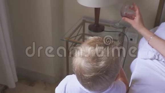一岁的孩子喝牛奶他妈妈喝葡萄酒家庭失调和酗酒的概念视频的预览图