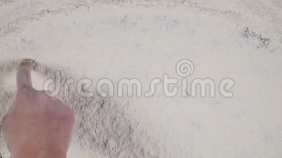 手指在白色面粉背景上写AREA顶视图4k视频的预览图
