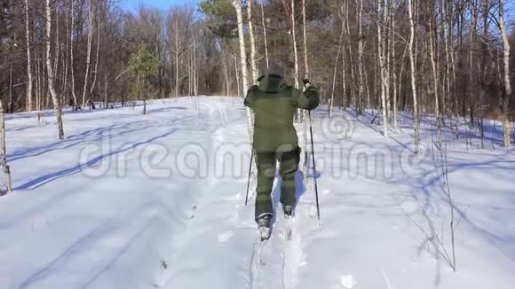 养老金领取者穿着滑雪板穿过冬季森林视频的预览图