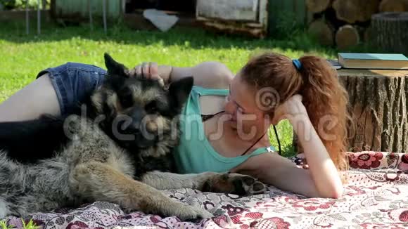 一个女孩在草地上和一只狗休息视频的预览图