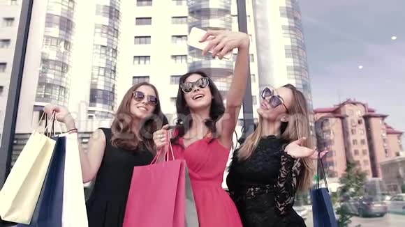 三个快乐的年轻女人在购物中心附近拍照视频的预览图