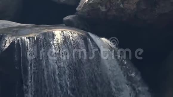 水流溅落在山瀑石上山河岩石上流淌的瀑布水中的溪流视频的预览图