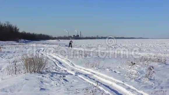 老人穿着滑雪板穿过冬天的田野视频的预览图
