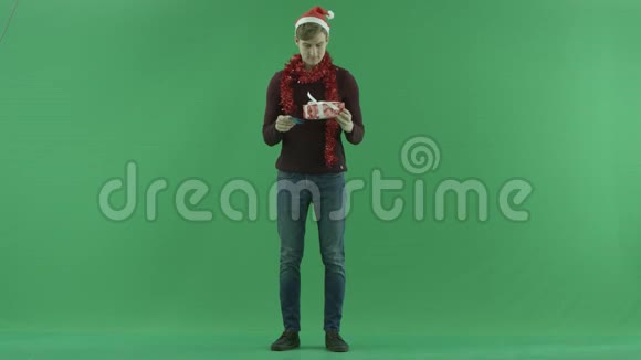 带信用卡和圣诞礼物的圣诞老人戴着圣诞帽的男人绿色的彩色钥匙背景视频的预览图