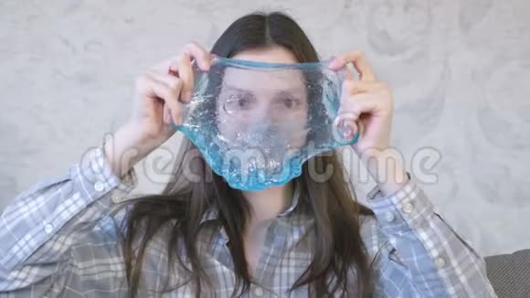 女人正在伸展一个蓝色的黏液坐在教练上玩从黏液里看过去视频的预览图