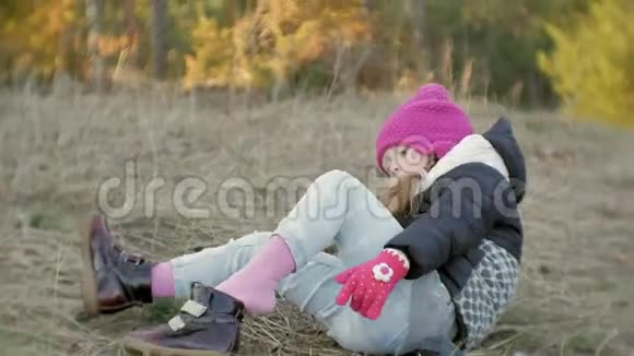 可爱的小女孩正在森林里的帐篷里玩耍穿着他的鞋子视频的预览图