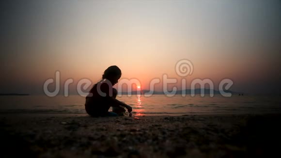 4的亚洲小女孩在海滩上玩沙夏天日落谷物和黑暗处理视频的预览图