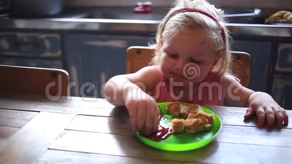 一个蹒跚学步的女孩在吃带有番茄酱的烤奶酪三明治视频的预览图