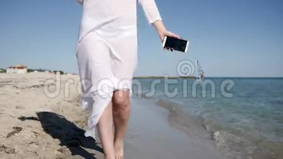 迷人的女孩在沙滩上水上散步手里拿着椰子鸡尾酒视频的预览图