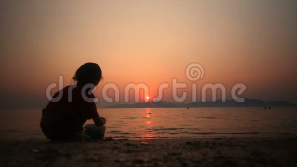 4的亚洲小女孩在海滩上玩沙夏天日落谷物和黑暗处理视频的预览图