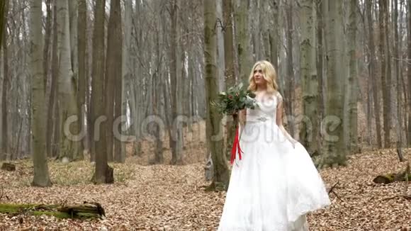美丽的新娘的肖像金发碧眼的卷发和可爱的微笑边走边闻着婚礼的花束视频的预览图