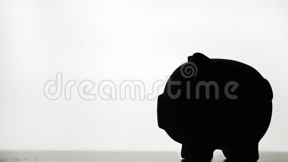 手将硬币插入储蓄罐在白色背景上储蓄和储蓄概念视频的预览图