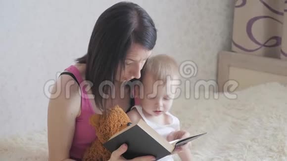 快乐的母亲在室内给孩子读一本书和妈妈一起读书给宝贝的甜蜜时刻视频的预览图
