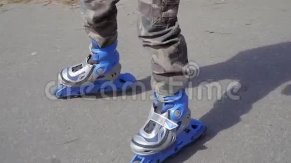 穿蓝色溜冰鞋的男孩骑在公园里视频的预览图