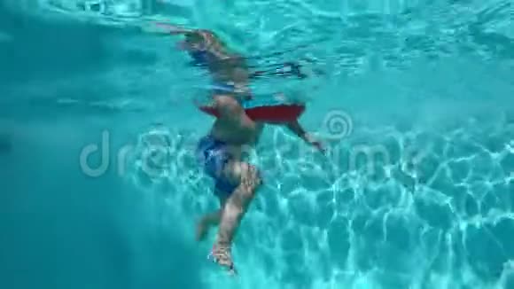 快乐的孩子在蓝色清澈的游泳池里玩视频的预览图