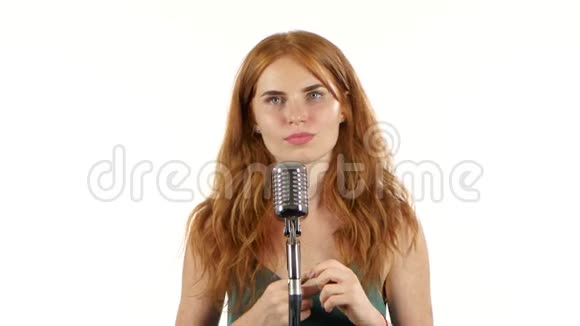 带雀斑的女孩用复古麦克风唱歌白色背景视频的预览图