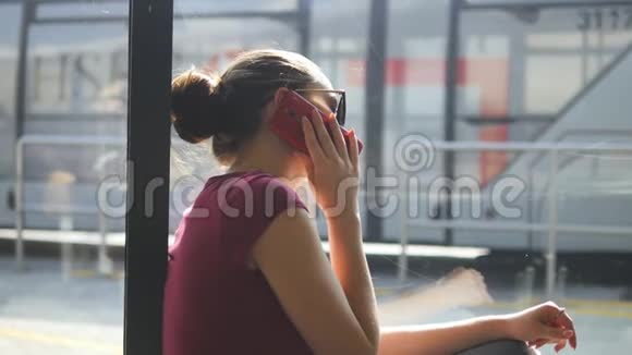 年轻女子坐在机场候机室的地板上打电话女孩在候机楼打手机视频的预览图