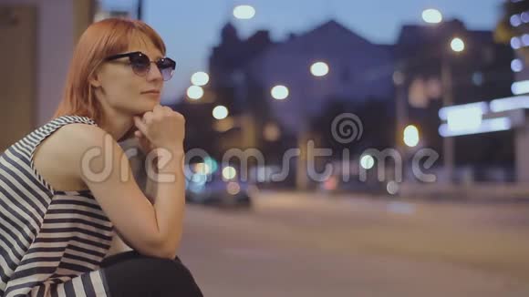 红发女人晚上坐在街上视频的预览图