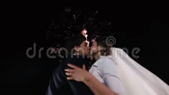 在烟火的背景下亲吻新婚夫妇的特写肖像视频的预览图