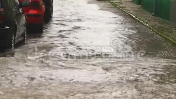城市里下着大雨一条水流缓慢的街道视频的预览图