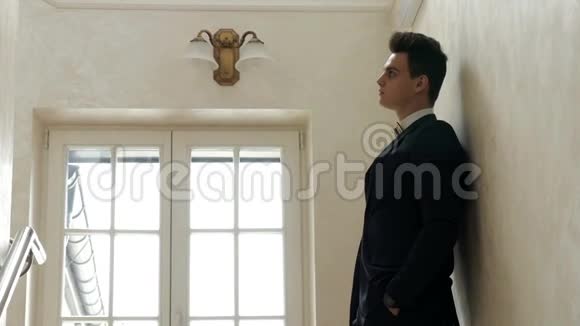 无聊的英俊新郎等着他的情人看着手表走上楼梯的肖像视频的预览图