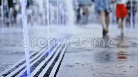 一个地板喷泉喷得很近一个女人带着一个孩子逃跑享受生活视频的预览图