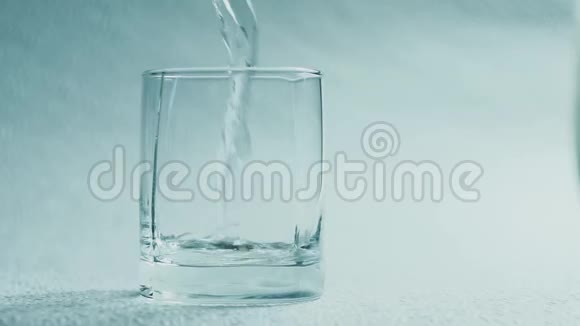 水倒在白色背景上的玻璃杯里视频的预览图