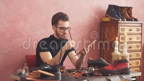 年轻设计师在现代室内鞋店工作时使用刷子视频的预览图