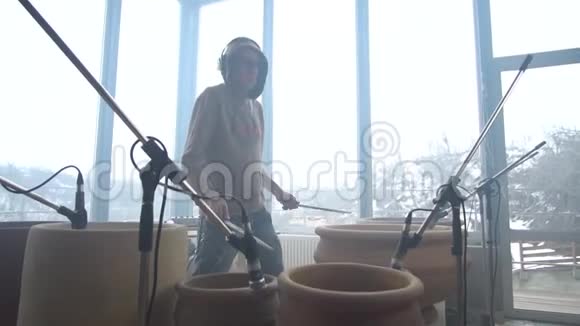 一位男音乐家在陶罐上录制旋律视频的预览图