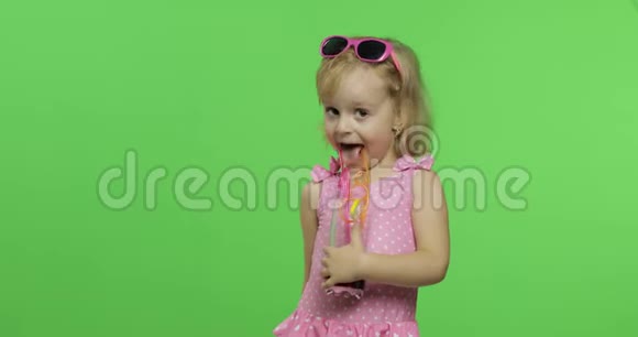 穿着粉红色泳衣的孩子用吸管喝果汁鸡尾酒色度键视频的预览图