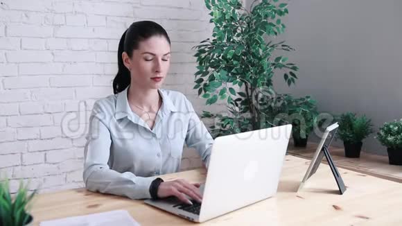 商务女性在使用笔记本电脑时头痛一个穿着又沮丧的女孩摸着她的头视频的预览图