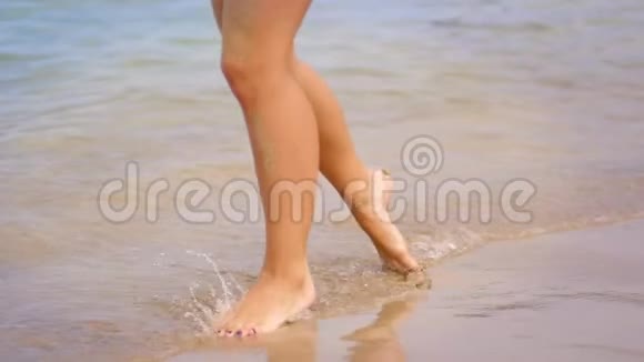 女孩的腿在水波上行走完美的女人腿在海边奔跑视频的预览图
