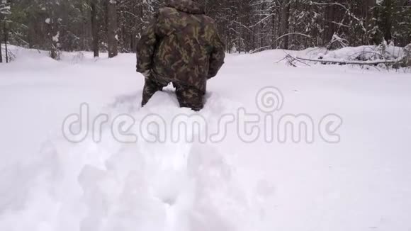 一个在冬天的森林里迷路的人走过厚厚的雪视频的预览图