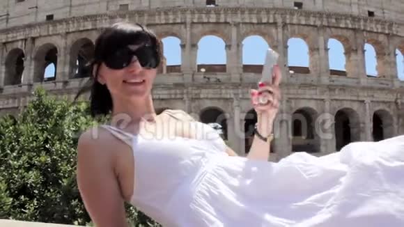 年轻的白种人女游客用手机在美丽的欧洲古城美景上自拍视频的预览图