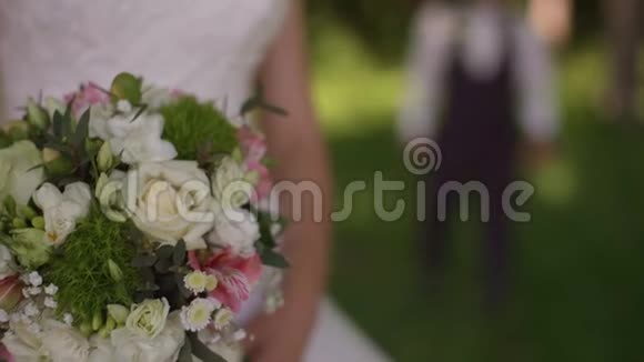 新郎来到迷人的金发新娘身后带着花束慢动作视频的预览图