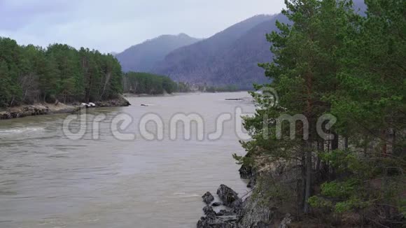一条宽阔的河流在两岸山林映衬下水流湍急视频的预览图