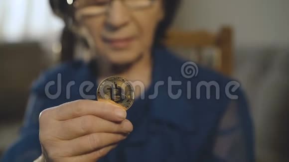 一位老妇人的画像在镜头前拿着一枚金色的比特币视频的预览图