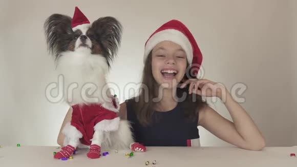 美丽的少女和狗穿着圣诞老人的服装尽情享受新年的欢乐视频的预览图