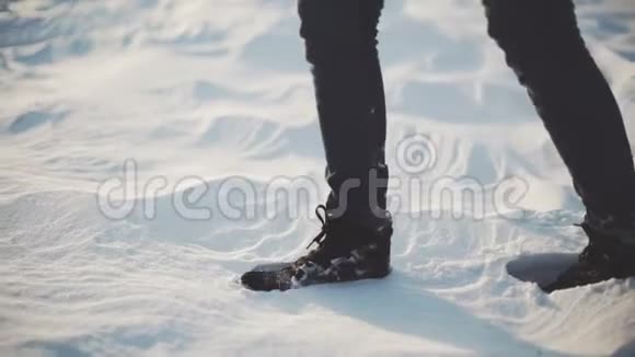 日落时分女人的脚在雪地沙漠上行走慢动作射击视频的预览图