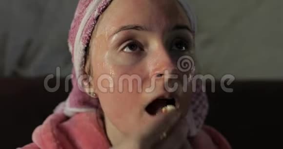 女人在电视上看深夜电影吃爆米花浴衣面膜视频的预览图